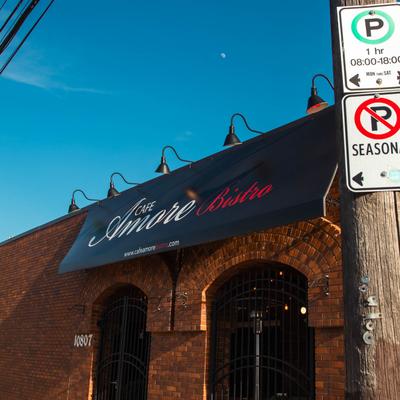 Brick building with a black Cafe Amore Bistro awning sign.