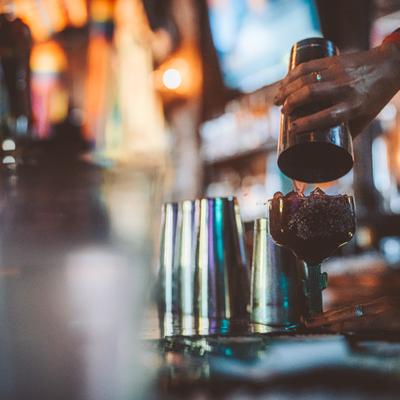 Bartender pouring cocktail using shaker