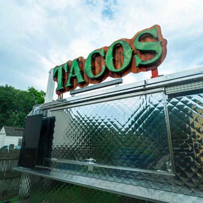 Taco truck with a green sign.