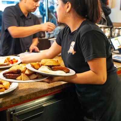A server delivering breakfast dishes.