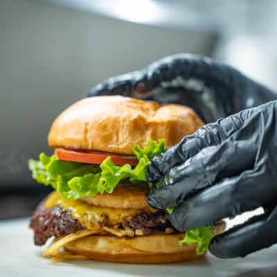 Burger being assembled on a kitchen counter, close-up.