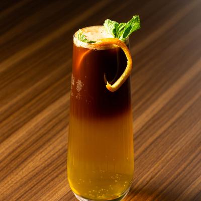 Turkish Bubbles drink garnished with a mint spring and a otenge peel.