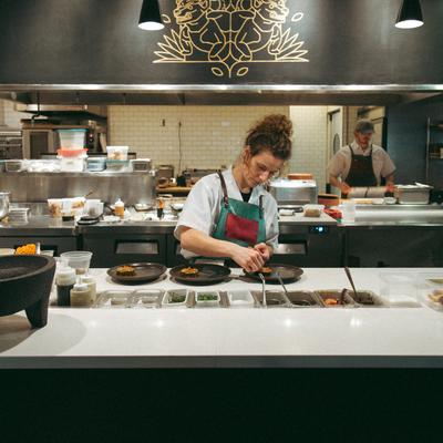 Chef plating dishes on the kitchen counter.