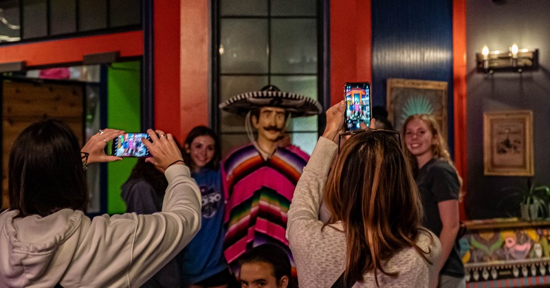 Customers posing with a Mariachi statue