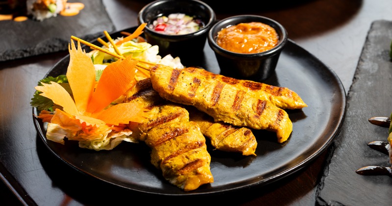 Grilled chicken on skewers served with peanut sauce and cucumber relish