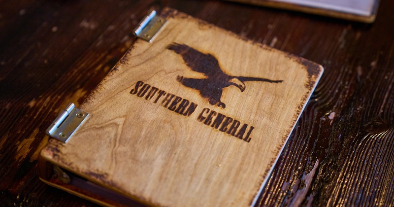 A wooden menu with the restaurant's logo