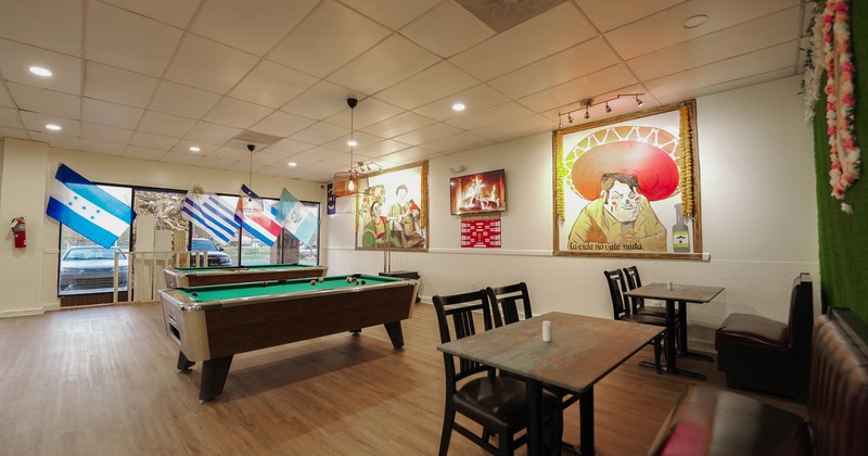 Interior, wide view, pool tables, tables and chairs, pictures on the wall