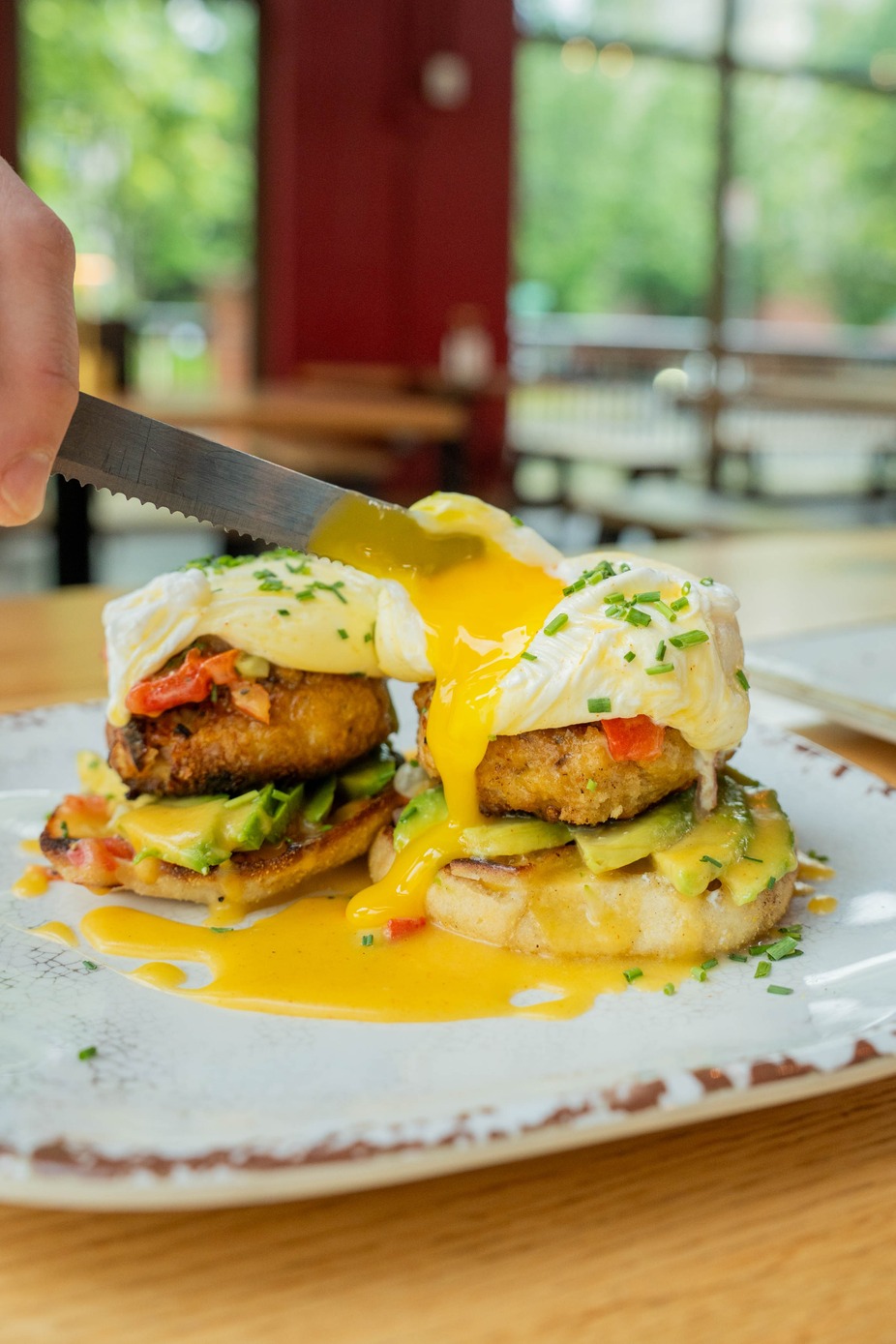 Pan-Seared Crab Cake Benedict - served with an avocado corn relish and a poached egg with Hollandaise on a toasted English muffin