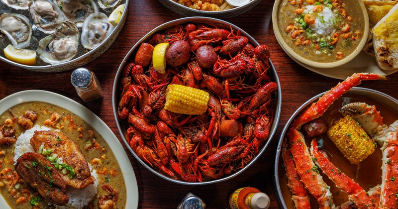 Craw fish boil plate, surrounded by assorted dishes, overhead view