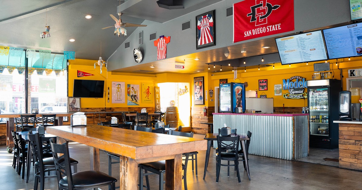 Interior, high tables and chairs with bar in the back