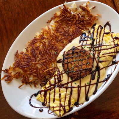 Southern Caprese Avo omelet, topped with a fried green tomato, and hash browns.