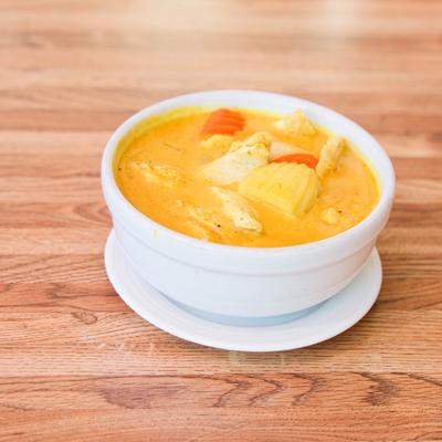 Bowl of Yellow Curry with chicken, potatoes, carrots, and yellow onions.