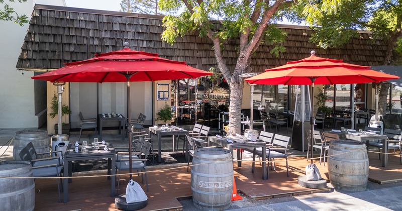 Outdoor seating area, dining tables and red parasols