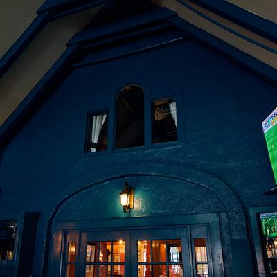 Blue restaurant exterior illuminated at night.