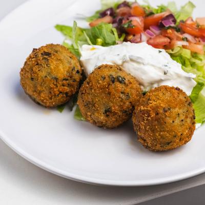Three falafel balls, served with tzatziki and salad.