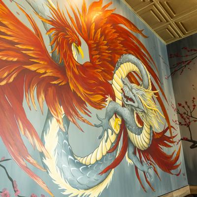 Mural art on a wall in dining area, depicting a fight between phoenix and dragon