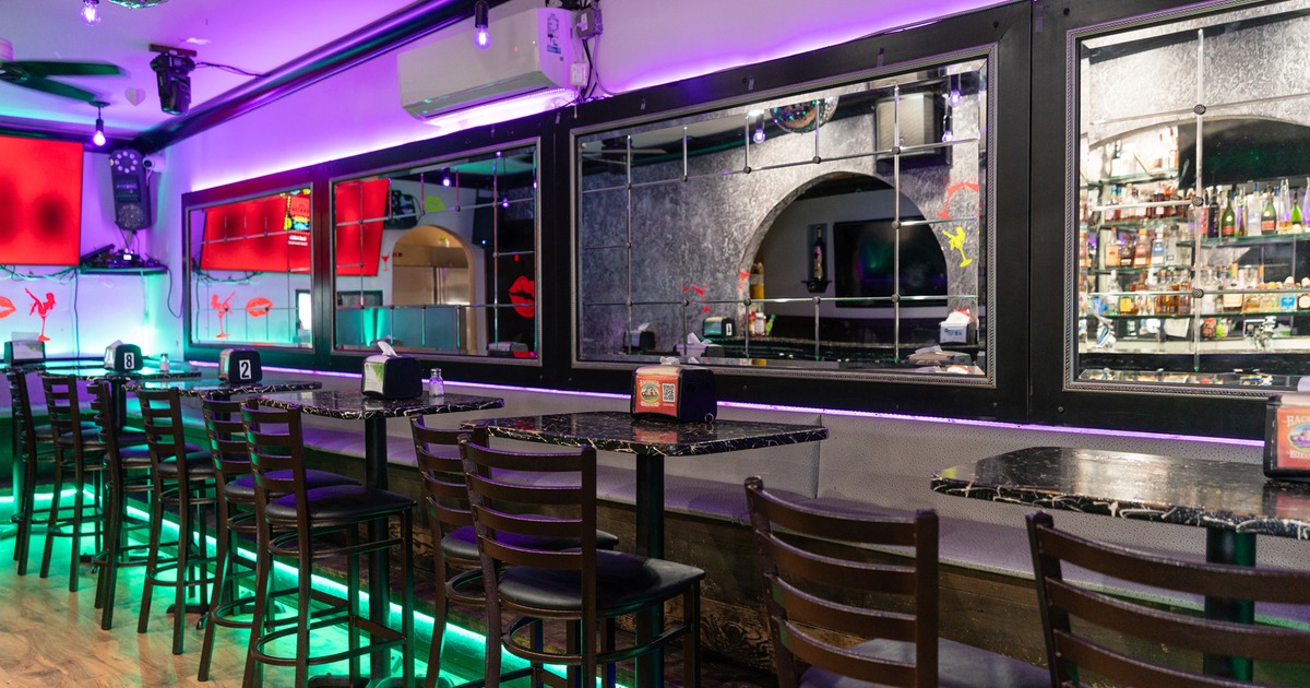 Interior space, seating area, lined-up tables, and decorative mirrors on the wall
