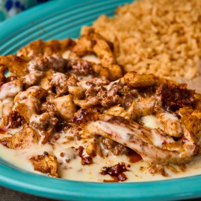Grilled chicken and chorizo with cheese sauce and seasoned rice.