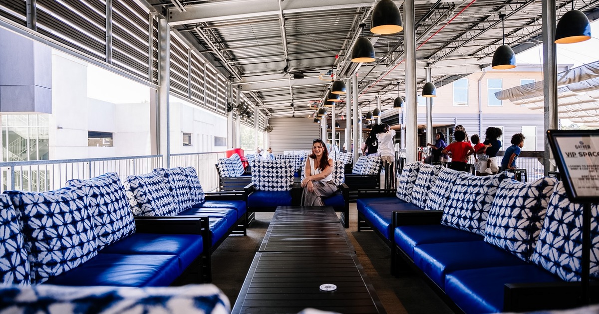 Blue leather sofas, white and blue patterned pillows, and coffee tables