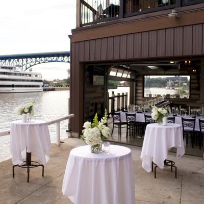 Exterior featuring a riverfront patio with a garage-door style opening and decorated tables.