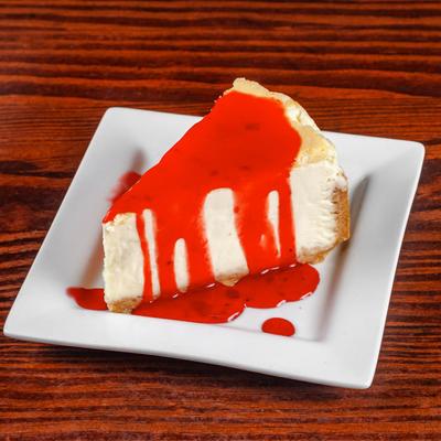 Cheesecake with red fruit sauce on top