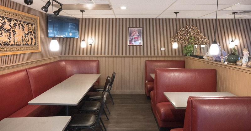 Interior of a restaurant with red booths, TV on the wall