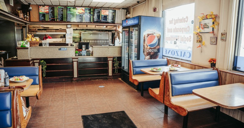 Interior, dining area, seating booths with tables, checkout counter in the back