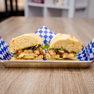 Grilled chicken sandwich with arugula, cheese, and apple.