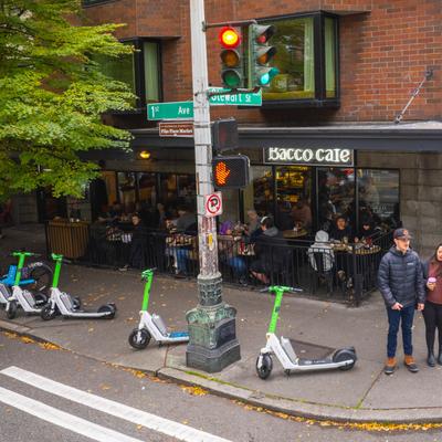 Outdoor seating area surrounded by parked electric scooters.