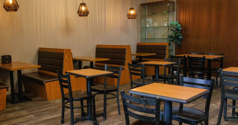 Interior with wooden tables and chairs and pendant lighting.
