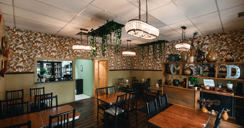 Interior, dining area, tables for four, floral pattern wallpapers, kitchen entrance