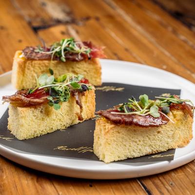 Beef tataki toast topped with microgreens.