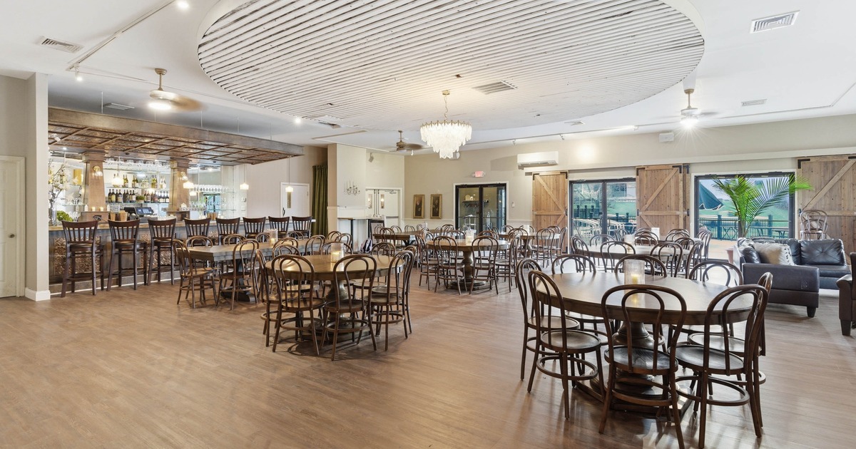 Dining area with wooden tables, bar, chandelier, and sliding barn doors
