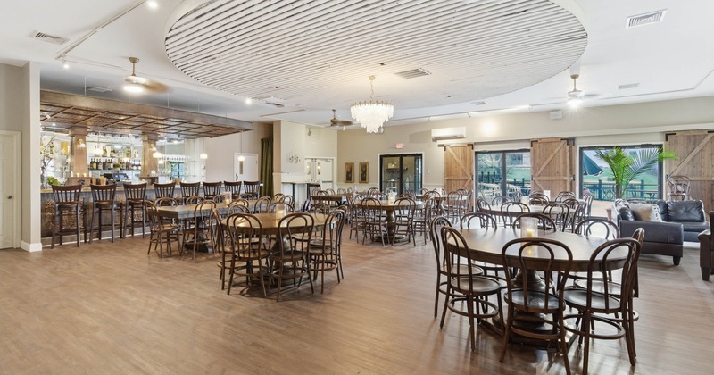 Dining area with wooden tables, bar, chandelier, and sliding barn doors