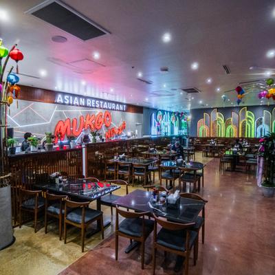 Dining area featuring colorful lantern decorations and neon architectural lighting.