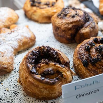 Cinnamon rolls resting in a display case, close-up.