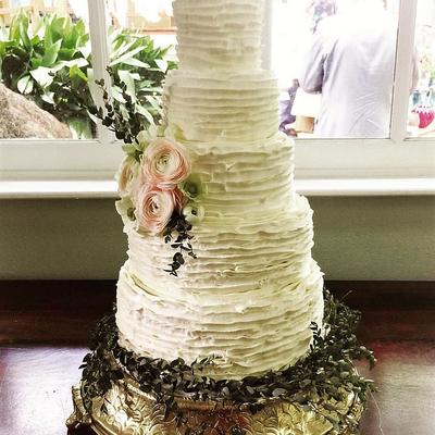 White wedding ruffle cake with floral decoration