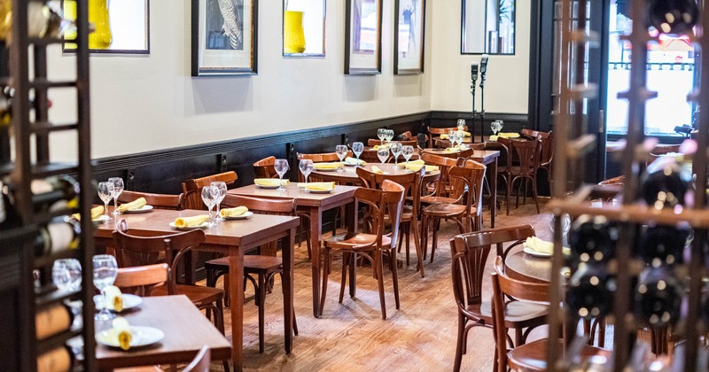 Interior, seating area, set tables, pictures on walls, wine racks