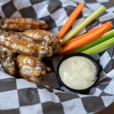 Garlic Parmesan wings served with celery, carrots, and a creamy sauce dip.