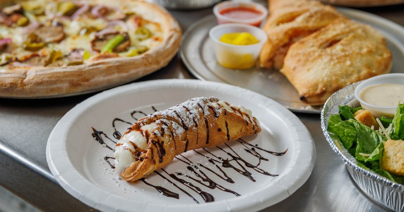 Cannoli with powdered sugar and chocolate drizzle