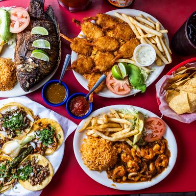 Assorted seafood, tacos,  and fried dishes served with fries and rice.