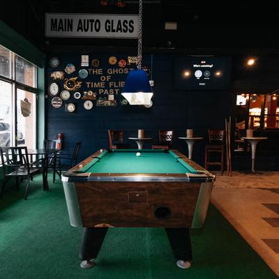 Interior space with a pool table, wall decor, and a dark-blue wall.
