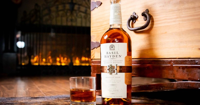 A bottle of bourbon on table by the fireplace.