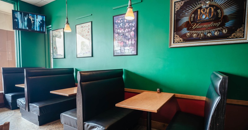 Interior, tables and sitting booths lined up, framed pictures on the wall