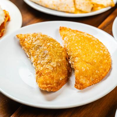 Two empanadas on a white plate.