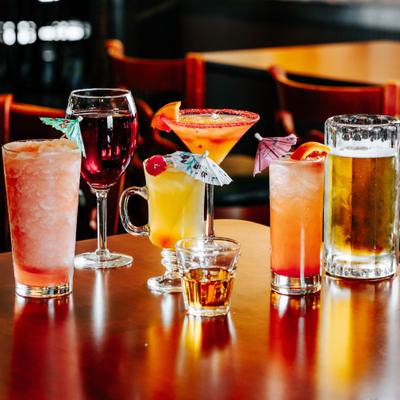 Variety of cocktails, beer, and wine on a table.