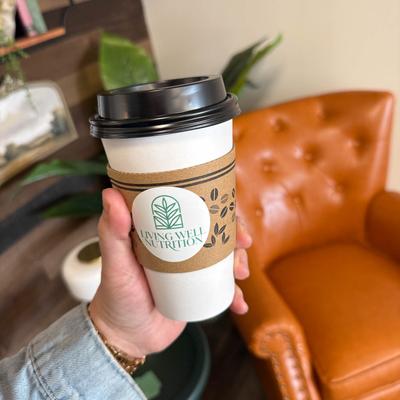 Hand holding a coffee cup featuring the 