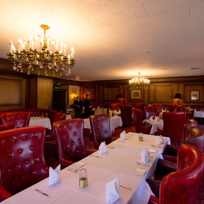 Interior, red leather chairs and fully set tables.