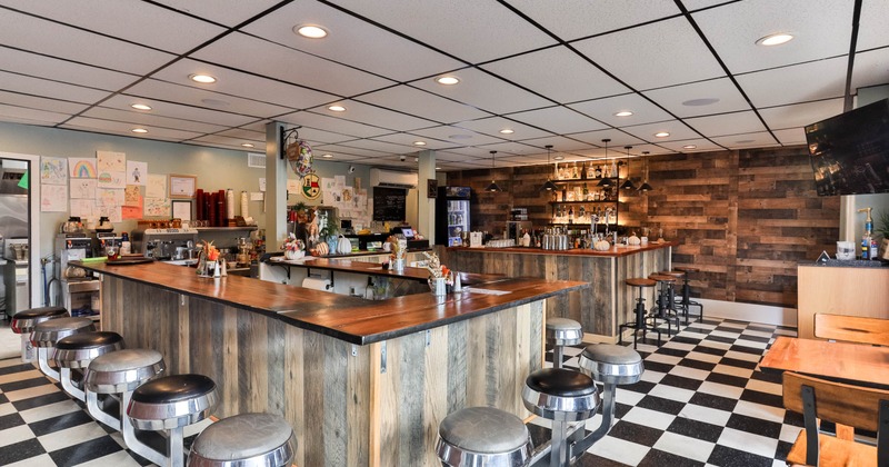 Interior, a bar with bar stools in the center of the cafe