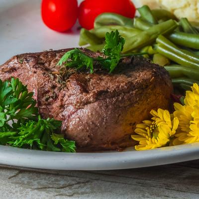 Grilled steak with green beans, parsley, and mashed potatoes.